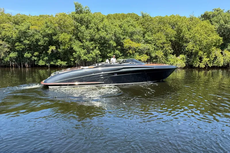 Sea Sea Yacht Photos Pics 2013 Riva Rivarama Super yacht cruising on a serene river with lush green trees.