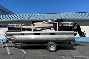 2019 Sun Tracker Bass Buggy 18 DLX pontoon boat on trailer, parked outdoors.