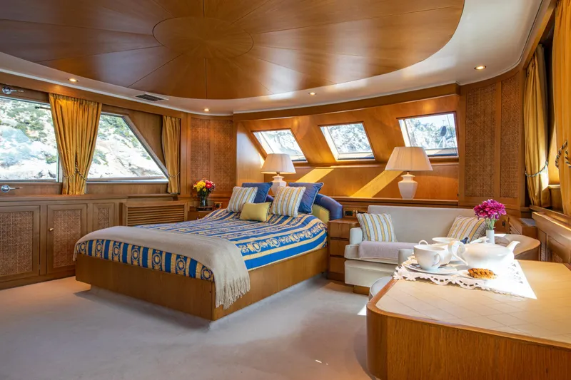 Monaco Yacht Photos Pics Luxurious 1982 Feadship Classic yacht bedroom with elegant wood paneling and plush decor.