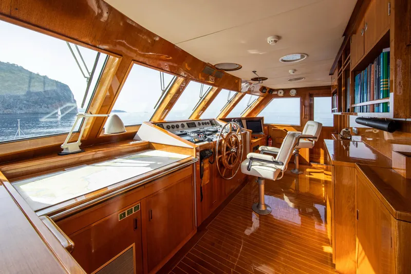 Monaco Yacht Photos Pics Luxurious 1982 Feadship Classic yacht interior with wooden helm, panoramic windows, and elegant seating.