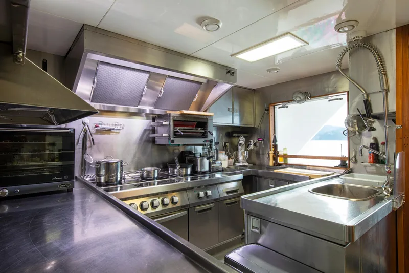 Monaco Yacht Photos Pics Stainless steel kitchen in 1982 Feadship Classic yacht, featuring modern appliances and ample workspace.