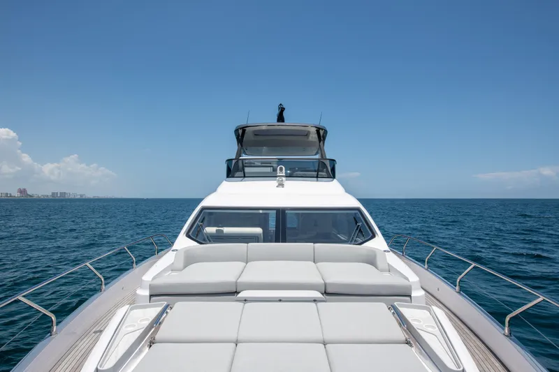 Crimson Yacht Photos Pics 2023 Azimut Fly 68 yacht cruising on open sea under clear blue sky.