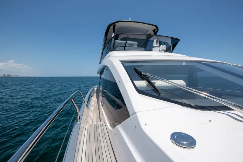 Crimson Yacht Photos Pics 2023 Azimut Fly 68 yacht cruising on open sea under clear blue sky.