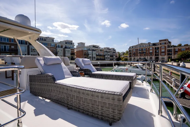 Forever Young Yacht Photos Pics Luxurious 2018 Absolute 58 Navetta yacht with sun loungers in a marina setting.