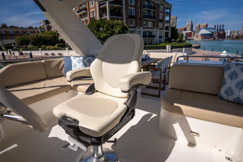 Forever Young Yacht Photos Pics Luxurious seating on 2018 Absolute 58 Navetta yacht, docked with cityscape view.