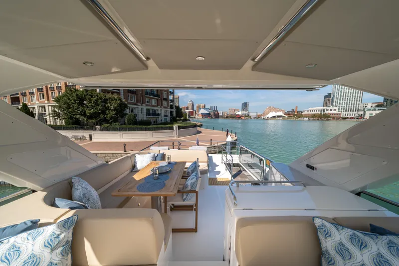 Forever Young Yacht Photos Pics Luxurious 2018 Absolute 58 Navetta yacht with elegant outdoor seating and scenic waterfront view.