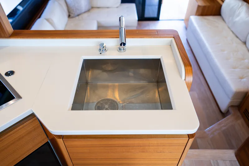 Forever Young Yacht Photos Pics Modern kitchen sink on 2018 Absolute 58 Navetta yacht, featuring sleek design and wood accents.