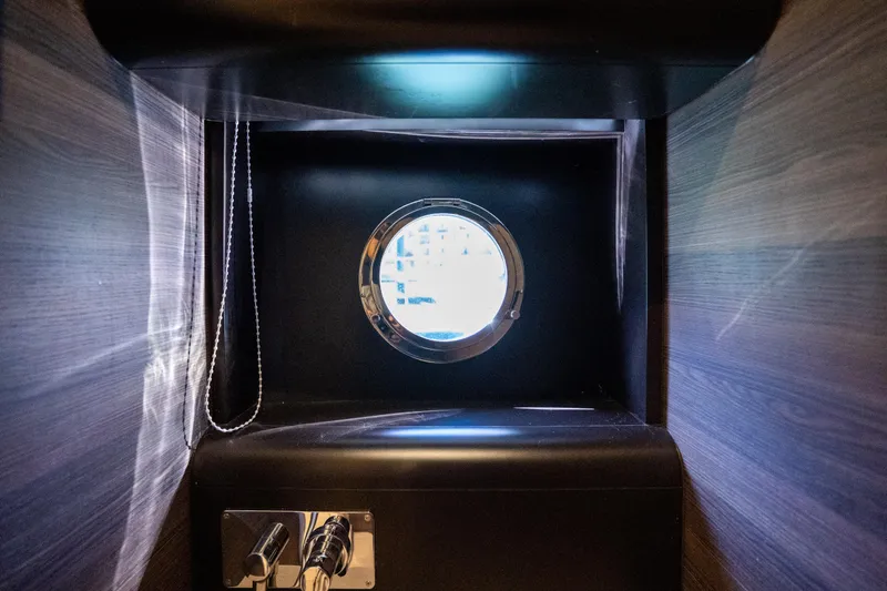 Forever Young Yacht Photos Pics Porthole view inside 2018 Absolute 58 Navetta yacht, featuring sleek wooden interior design.