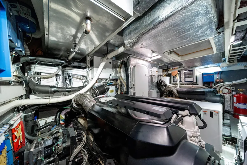 Forever Young Yacht Photos Pics Engine room of 2018 Absolute 58 Navetta yacht, showcasing complex machinery and piping.