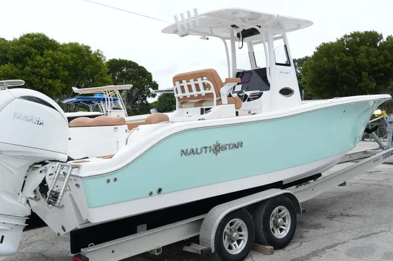  Yacht Photos Pics 2025 NauticStar 252 Legacy boat on trailer, featuring Yamaha engine, light blue hull.
