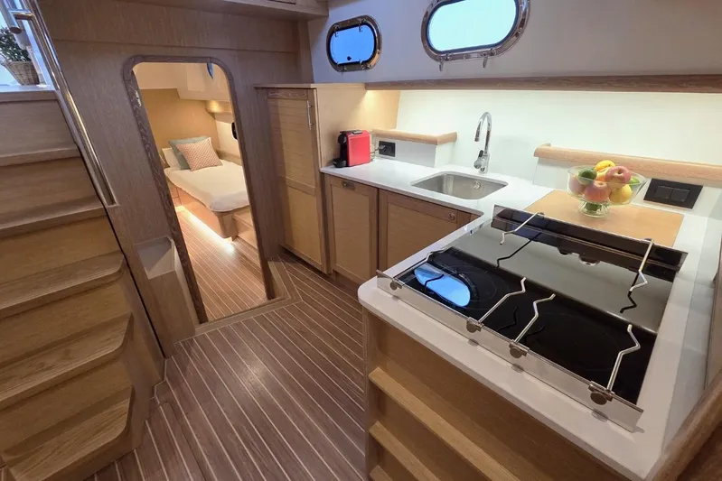  Yacht Photos Pics 2025 Sasga Yachts Menorquin 48 interior kitchen with modern amenities and cozy bedroom.