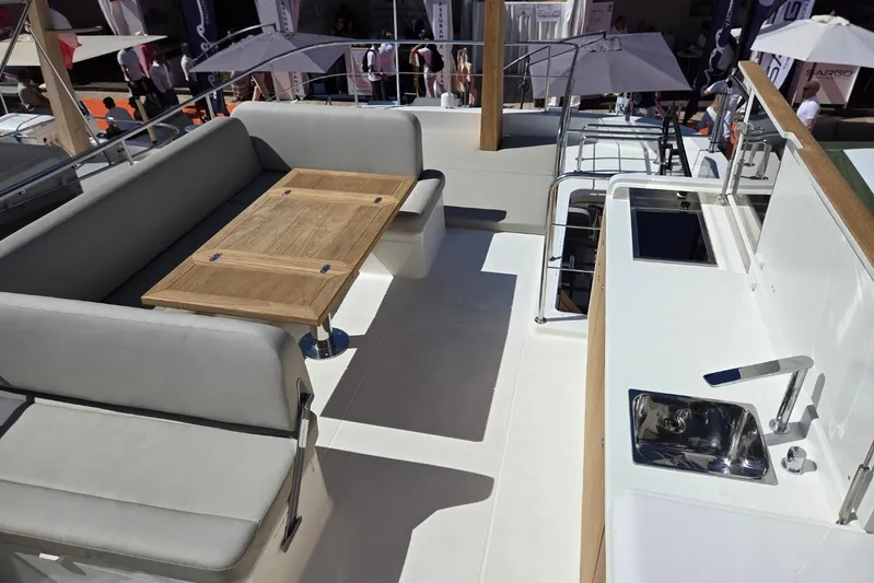  Yacht Photos Pics 2025 Sasga Yachts Menorquin 48 deck with seating, table, and kitchenette.