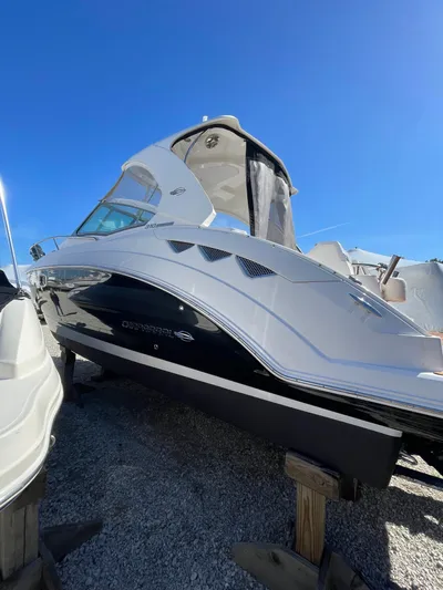 Yacht Photos Pics 2018 Chaparral 310 Signature boat displayed on stands under clear blue sky.