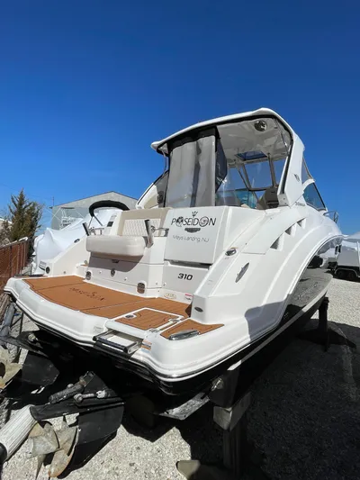  Yacht Photos Pics 2018 Chaparral 310 Signature boat with sleek design, docked under clear blue sky.