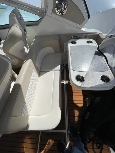 Yacht Photos Pics 2018 Chaparral 310 Signature boat interior with seating and table, featuring elegant design and wood flooring.