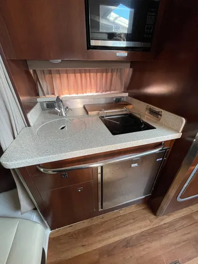  Yacht Photos Pics 2018 Chaparral 310 Signature yacht kitchen with modern appliances and wood finish.