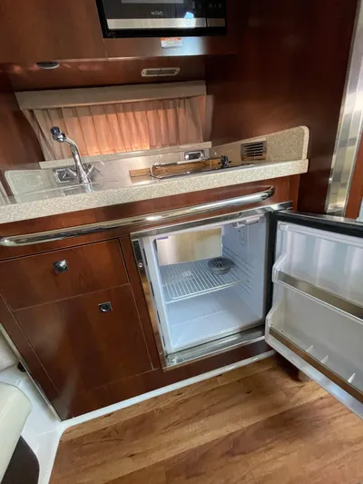  Yacht Photos Pics 2018 Chaparral 310 Signature yacht interior with kitchenette and open mini fridge.