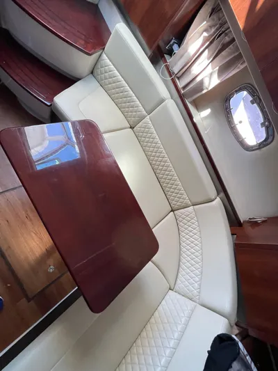  Yacht Photos Pics 2018 Chaparral 310 Signature interior with cream leather seating and wooden table.