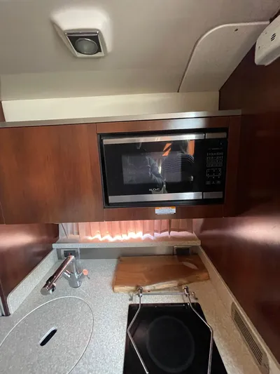  Yacht Photos Pics 2018 Chaparral 310 Signature kitchen with microwave, sink, and stove.