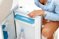 Woman accessing mini fridge on 2024 Quicksilver 805 Open boat.