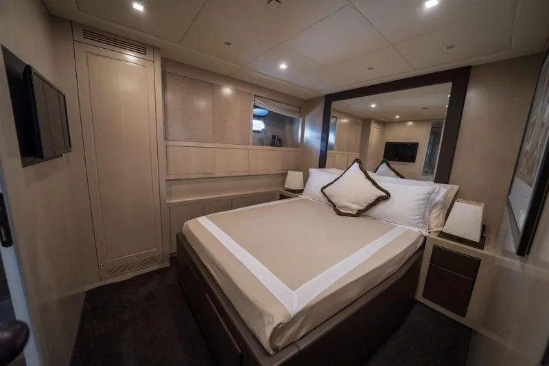 Manu Yacht Photos Pics Luxurious bedroom interior of 2006 Mangusta 92 yacht with elegant furnishings and ambient lighting.