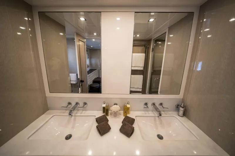 Manu Yacht Photos Pics Luxurious bathroom in 2006 Mangusta 92 yacht with dual sinks and elegant decor.