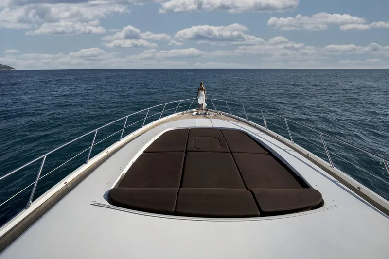 Manu Yacht Photos Pics Luxury Mangusta 92 yacht cruising on open sea, 2006 model, with person on deck.