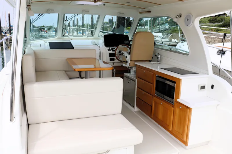 Polo Lounge Yacht Photos Pics 2020 Back Cove 34O yacht interior with seating, table, and kitchenette.