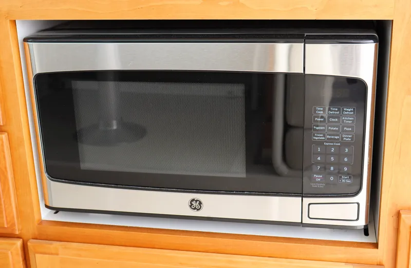 Polo Lounge Yacht Photos Pics A built-in GE microwave oven with a stainless steel finish, set in wooden cabinetry.