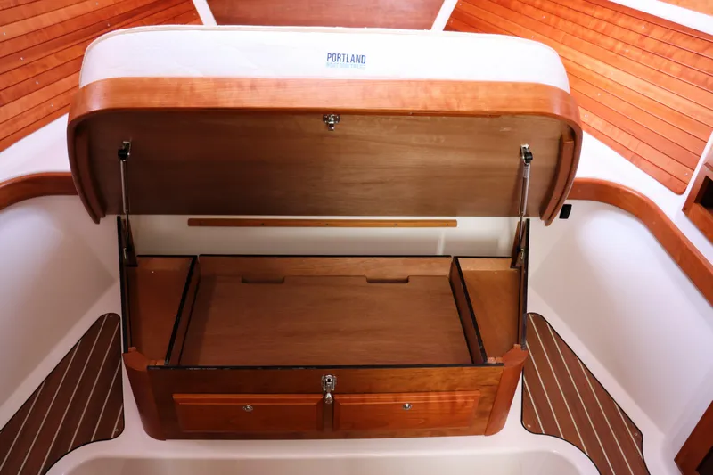 Polo Lounge Yacht Photos Pics 2020 Back Cove 34O boat interior with open wooden storage compartment.