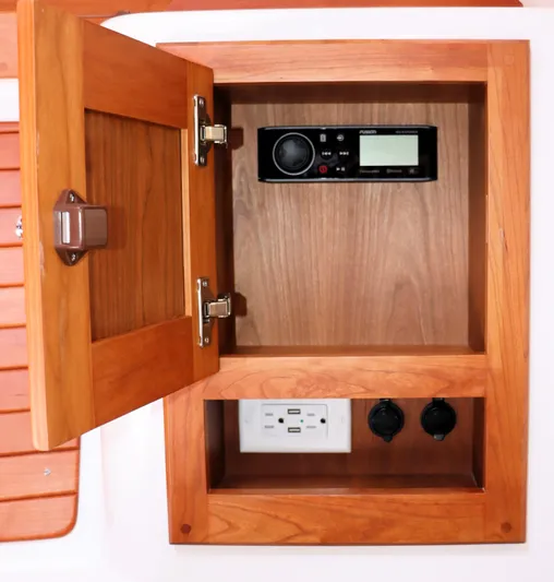 Polo Lounge Yacht Photos Pics Wooden cabinet with open door, revealing a stereo system and electrical outlets on a 2020 Back Cove 34O.