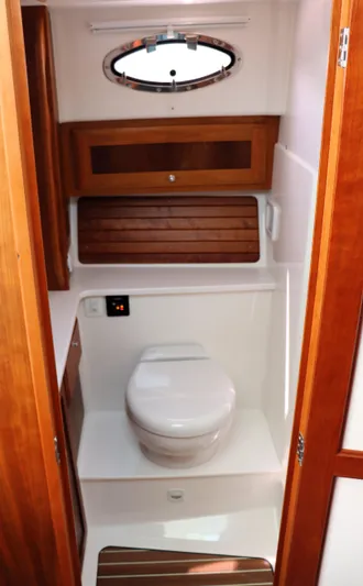 Polo Lounge Yacht Photos Pics 2020 Back Cove 34O yacht bathroom with wooden cabinetry and porthole window.