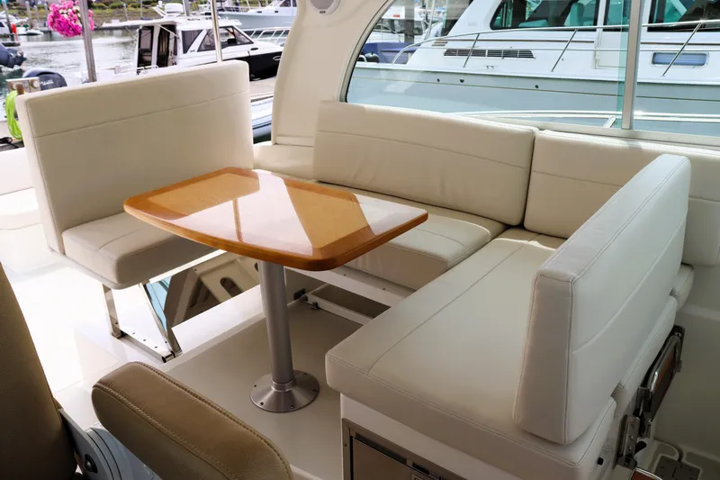 Polo Lounge Yacht Photos Pics 2020 Back Cove 34O yacht interior with white seating and wooden table.