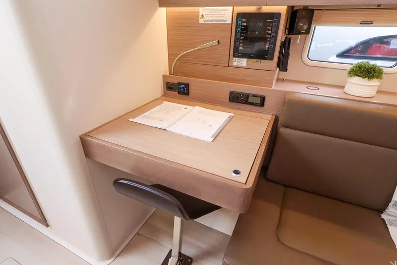  Yacht Photos Pics Modern interior of 2025 Hanse 458 yacht with desk, seating, and control panel.