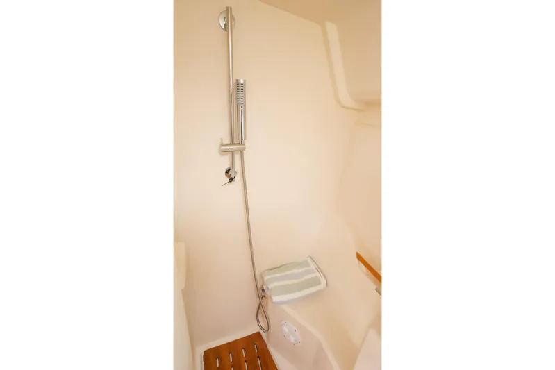  Yacht Photos Pics Modern shower area in 2025 Hanse 458 yacht, featuring sleek design and wooden flooring.
