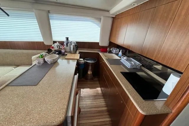  Yacht Photos Pics Interior of 2008 Viking 52 Convertible yacht kitchen with wooden cabinetry and modern appliances.