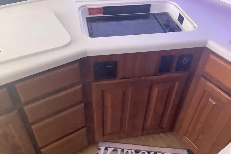 Fourth Quarter Yacht Photos Pics 1994 Viking 50' Convertible Sportfish kitchen with wooden cabinets and built-in stove.
