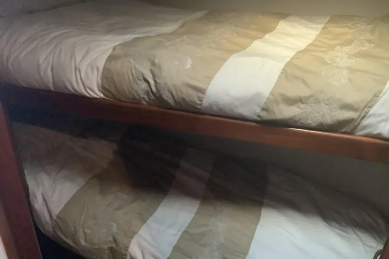Fourth Quarter Yacht Photos Pics Bunk beds in 1994 Viking 50' Convertible Sportfish cabin, featuring beige and white bedding.