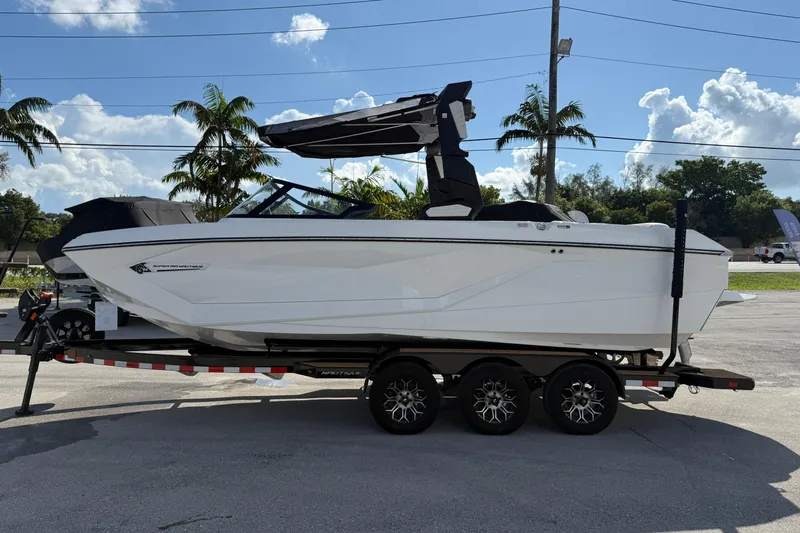  Yacht Photos Pics 2022 Nautique Super Air Nautique G23 boat on trailer, parked outdoors.