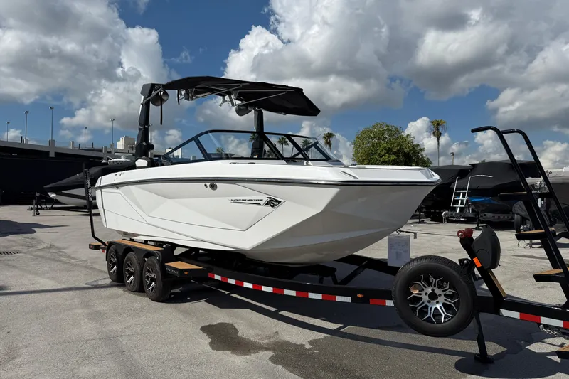  Yacht Photos Pics 2022 Nautique Super Air Nautique G23 boat on trailer under cloudy sky.