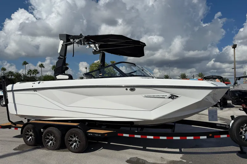  Yacht Photos Pics 2022 Nautique Super Air Nautique G23 boat on trailer under cloudy sky.