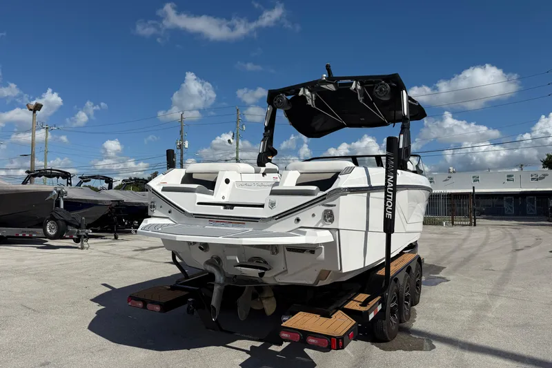  Yacht Photos Pics 2022 Nautique Super Air Nautique G23 boat on trailer under blue sky.