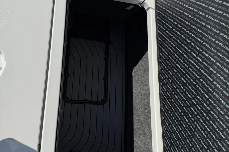  Yacht Photos Pics 2022 Nautique Super Air Nautique G23 storage compartment with sleek black interior design.