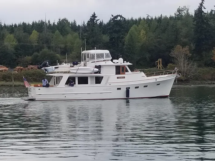 Legacy Yacht Photos Pics 1981 Ocean Alexander 50 Pilothouse on calm water near forest.