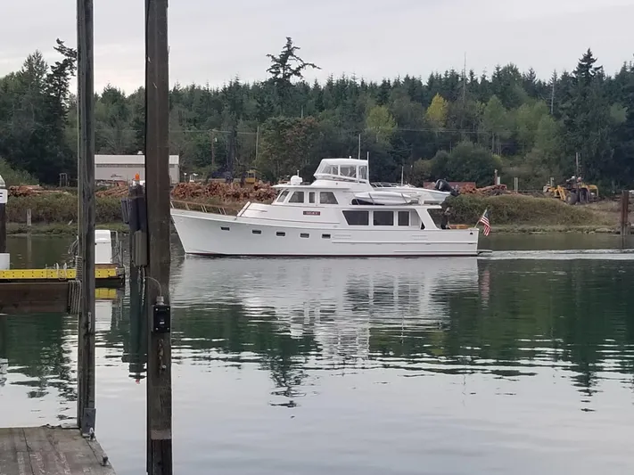 Legacy Yacht Photos Pics 1981 Ocean Alexander 50 Pilothouse on calm water with forest backdrop.