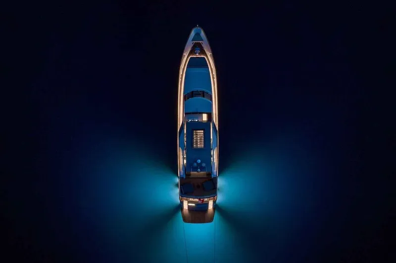  Yacht Photos Pics Aerial view of illuminated 1985 Heesen Pleasure Vessel on dark water.