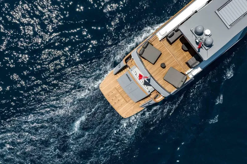  Yacht Photos Pics Aerial view of 1985 Heesen Pleasure Vessel cruising on sparkling blue water.