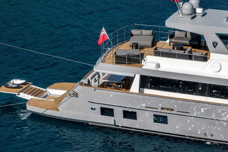  Yacht Photos Pics Luxurious 1985 Heesen Pleasure Vessel on serene blue waters, featuring elegant deck seating.