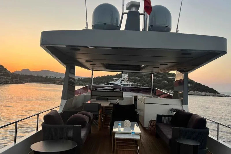  Yacht Photos Pics Luxurious 1985 Heesen pleasure vessel at sunset, featuring elegant outdoor seating and scenic views.