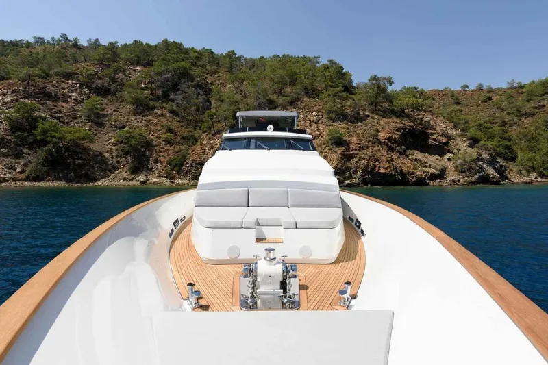  Yacht Photos Pics 1985 Heesen Pleasure Vessel cruising near rocky coastline under clear blue sky.
